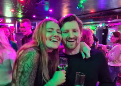 Lachende jonge mensen met op de achtergrond een Mixed Grooves feest.