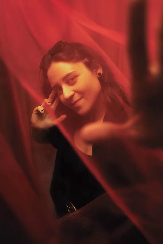 Denise Lopes looking in the camera surronded by red laser beams