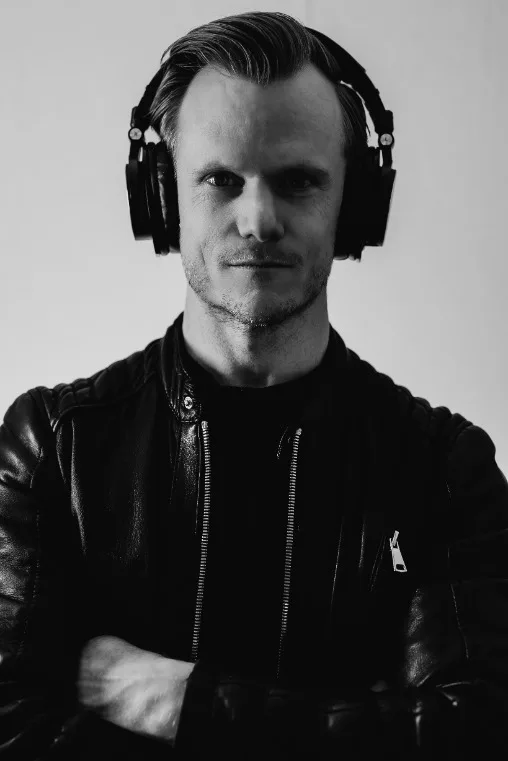 DJ HIGHERPRINZ met hoofdtelefoon en armen gekruist kijkend in de camera